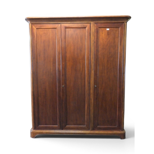 23 - A contemporary stained teak Willis & Gambier three door wardrobe with moulded cornice over three... 