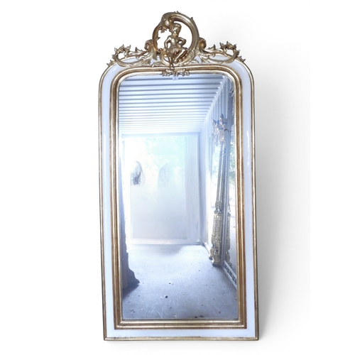 33 - A large 20th century white and gilt framed wall mirror with shaped mirror pane within moulded frame ... 