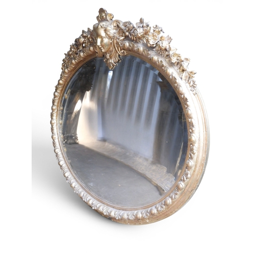 36 - An impressively large 19th century oval framed wall mirror with moulded frame surmounted with ladies... 