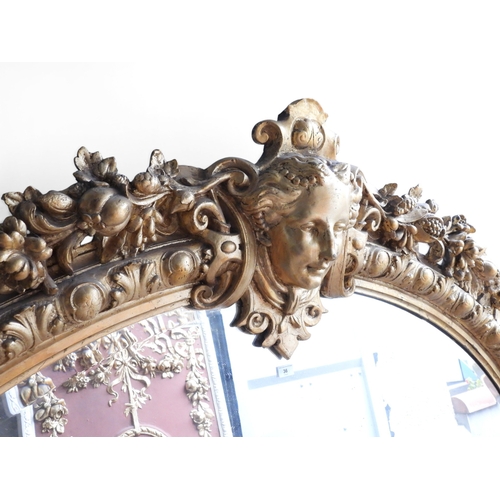 36 - An impressively large 19th century oval framed wall mirror with moulded frame surmounted with ladies... 