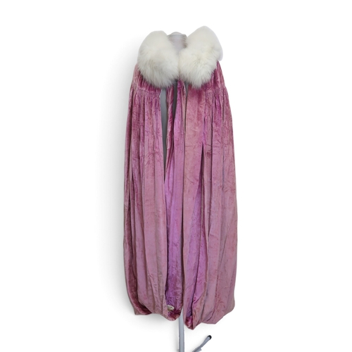 8005 - A circa 1930s pink silk velvet cape with white fox fur collar, lined with champagne satin; a blue si... 