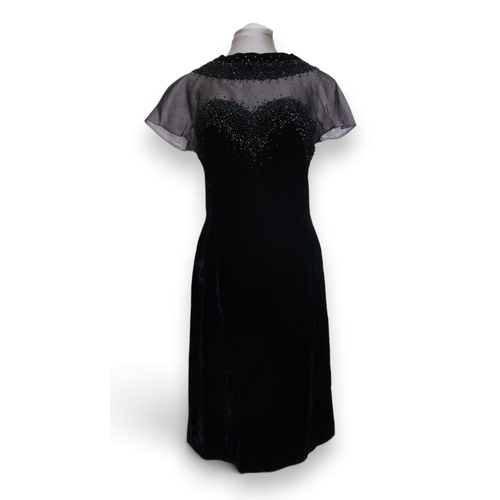 8015 - Three 1950s couture Norman Hartnell dresses comprising a black velvet cocktail dress with beaded swe... 