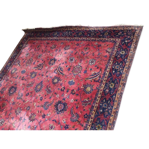 2080 - AN IMPRESSIVE LARGE RED GROUND SAROUK RUG with all-over floral/foliate patterned ground within dark ... 