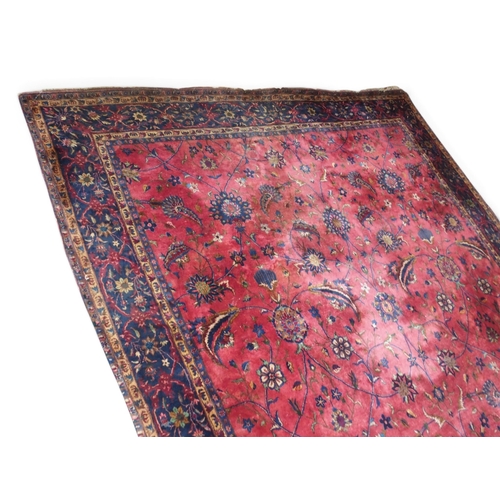 2080 - AN IMPRESSIVE LARGE RED GROUND SAROUK RUG with all-over floral/foliate patterned ground within dark ... 