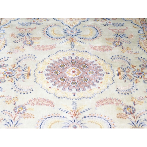 2081 - A LIGHT GREEN GROUND FINE PILE TABRIZ RUGwith beige sunburst central medallion and lighter spandrels... 