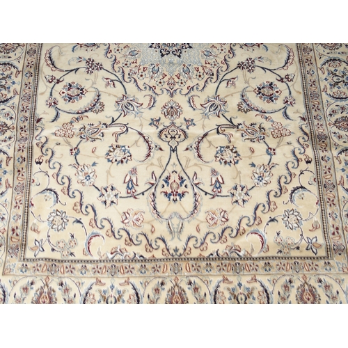 2084 - AN IVORY GROUND FINE NAIN RUGwith light blue sunburst central medallion on floral/foliate patterned ... 