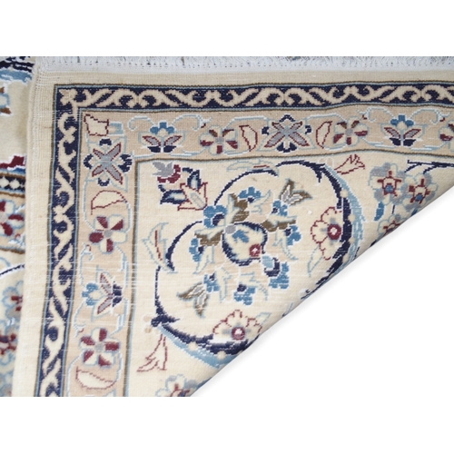 2084 - AN IVORY GROUND FINE NAIN RUGwith light blue sunburst central medallion on floral/foliate patterned ... 