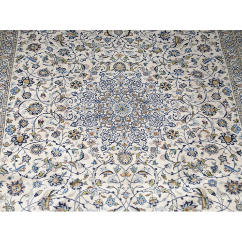2085 - A CREAM GROUND FINE PILE KASHAN RUGwith multicoloured sunburst central medallion on extensive floral... 