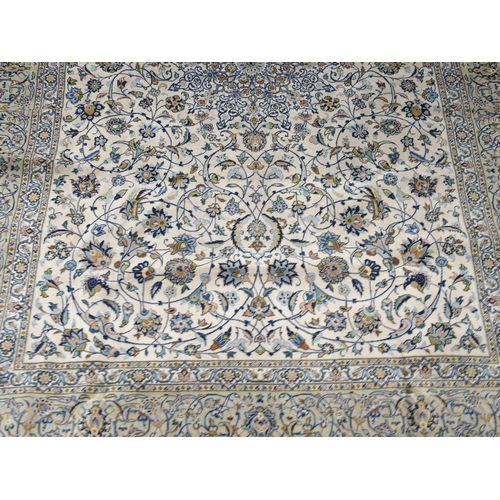 2085 - A CREAM GROUND FINE PILE KASHAN RUGwith multicoloured sunburst central medallion on extensive floral... 