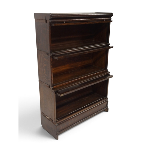 2001 - AN EARLY 20TH CENTURY OAK THREE TIER SECTIONAL BOOKCASE&nbsp;with three glazed front sections on pli... 