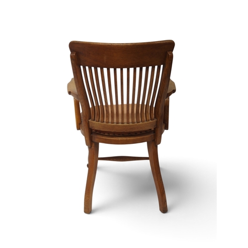2005 - AN EARLY 20TH CENTURY OAK ARTS & CRAFTS STYLE COMB BACK DESK ARMCHAIR&nbsp;with shaped arms flan... 