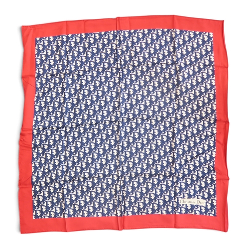 8051 - A Christian Dior silk scarf with blue monogram print on white ground with red border; together with ... 