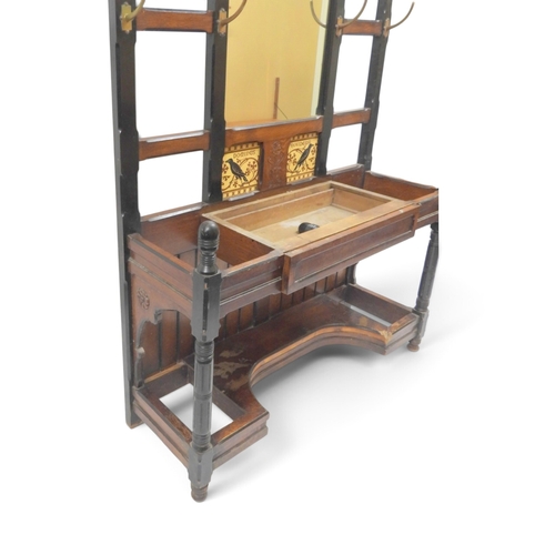 2017 - A LATE 19TH CENTURY OAK AND EBONISED ARTS & CRAFTS MIRROR BACKED HALLSTANDwith spindle mounted s... 
