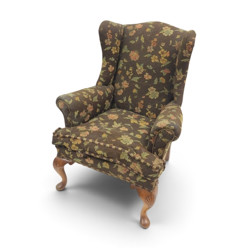 2020 - AN EARLY 20TH CENTURY BROWN FLORAL UPHOLSTERED WINGBACK ARMCHAIR&nbsp;with rolled arms on cabriole s... 