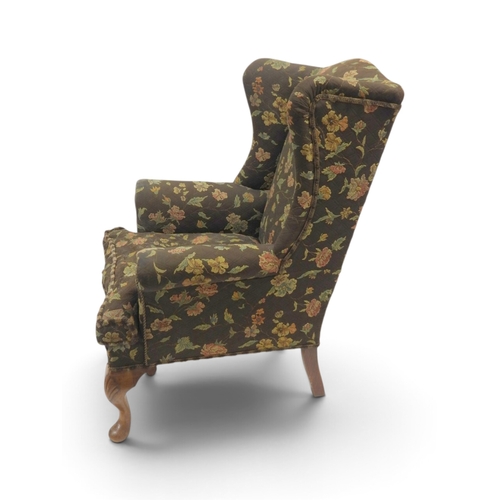 2020 - AN EARLY 20TH CENTURY BROWN FLORAL UPHOLSTERED WINGBACK ARMCHAIR&nbsp;with rolled arms on cabriole s... 