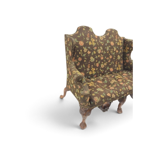 2021 - A 19TH CENTURY CONTINENTAL FLORAL UPHOLSTERED HUMPED WINGBACK SETTEEwith rolled arms on three carved... 