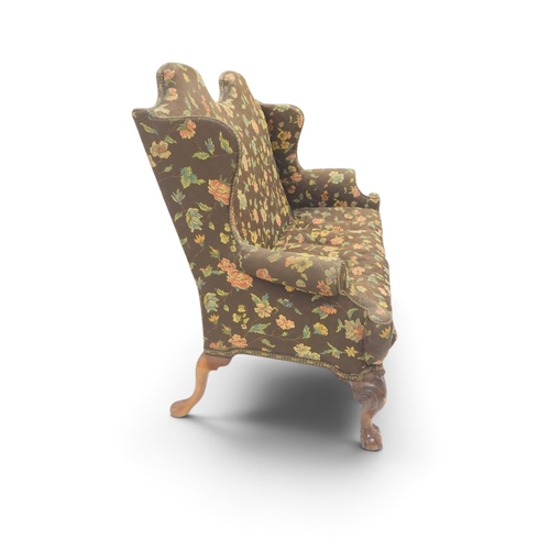 2021 - A 19TH CENTURY CONTINENTAL FLORAL UPHOLSTERED HUMPED WINGBACK SETTEEwith rolled arms on three carved... 