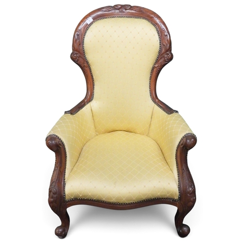 12 - A Victorian walnut framed parlour armchair with gilt yellow upholstery on carved scrolled supports, ... 