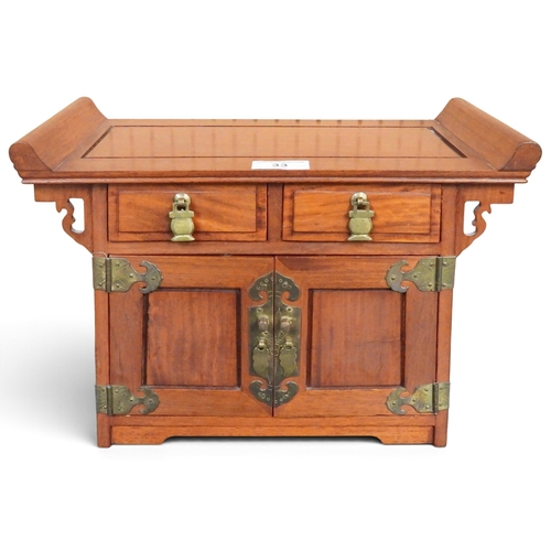 33 - A 20th century Chinese elm jewellery chest in the form of a altar cabinet with two short drawers ove... 