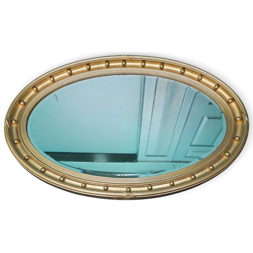 42 - A 20th century oval gilt framed bevelled glass wall mirror, 64cm high x 99cm wide