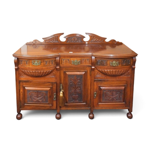 43 - A late Victorian mahogany sideboard with three short drawers over three cabinet doors on ball suppor... 