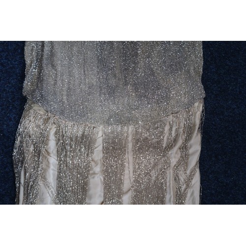 8003 - A 1920s flapper dress with scoop neckline, beaded drop waist silhouette and beaded fringe skirt, the... 