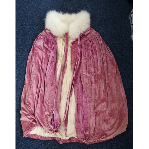 8005 - A circa 1930s pink silk velvet cape with white fox fur collar, lined with champagne satin; a blue si... 