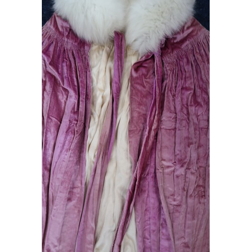 8005 - A circa 1930s pink silk velvet cape with white fox fur collar, lined with champagne satin; a blue si... 