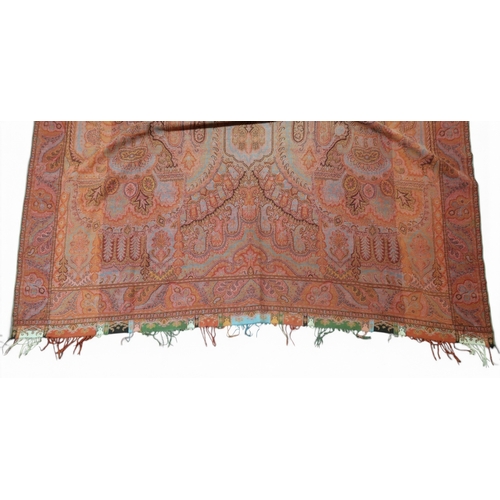 8040 - A long Paisley shawl woven in polychrome wools, the central cream cartouche with palmettes and sprig... 