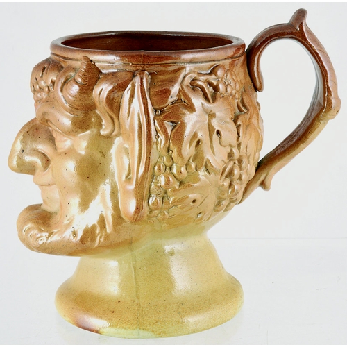 193 - SATYR JUG. 7ins tall, variating tan salt glaze. Bearded satyr/ bacchus type character jug, rear hand... 