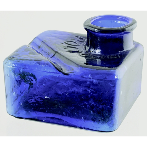 570 - POLYGON INKWELL. 2ins tall. Square shape, cobalt blue ink with pen rest to rear. Embossed POLYGON ar... 