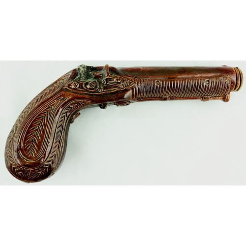 428 - EARLY SALT GLAZE PISTOL FLASK. 9ins long. Detailed pistol modelled flask in variating brown shiny fi... 