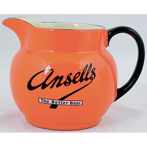 48 - ANSELLS BEER JUG. 4.25ins tall. bright orange glaze, rear black handle ANSELLS/ THE BETTER BEER in b... 