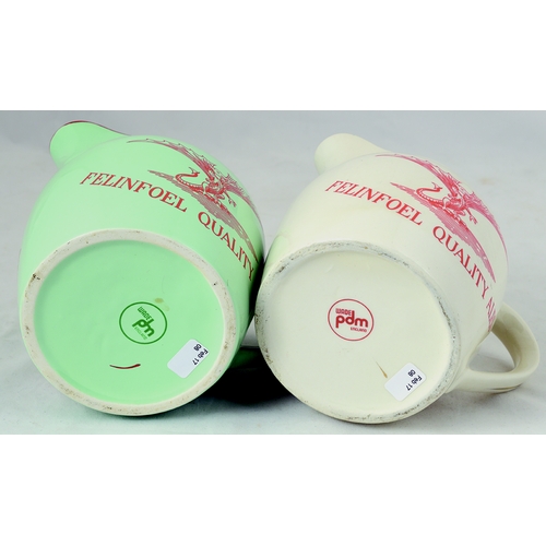 67 - FELINFOEL ALES JUG DUO. 5ins tall. One cream, other pale green glaze, both with red transfers either... 