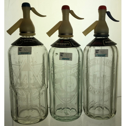 80 - SODA SYPHON TRIO. 12ins, clear glass, acid etched, all with triggers, Hampshire, Manchester & Devize... 