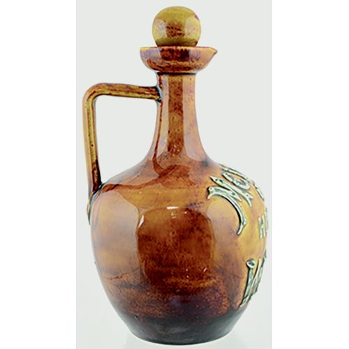 85 - MELROSE ARTWARE WHISKY JUG. (WG pg 29) 8.5ins tall to top of (original) stopper. Mottled tan glaze, ... 