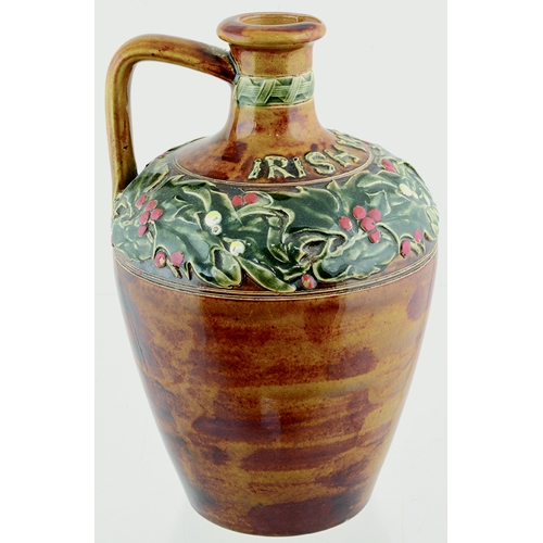 87 - ARTWARE IRISH WHISKY JUG. (WG pg 166) 8ins tall. Mottled tan glaze, shoulder area with raised berrie... 