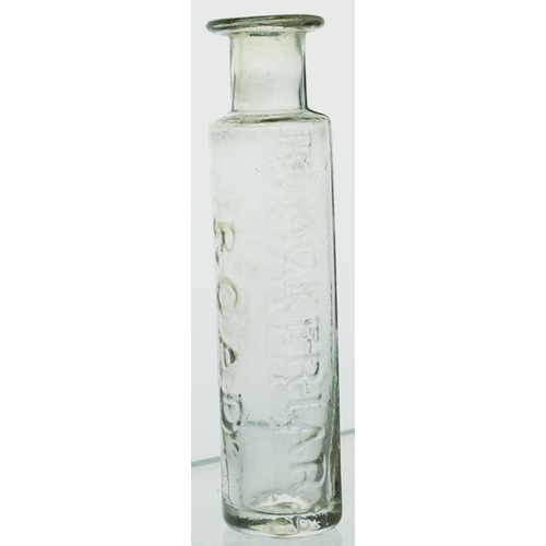 105 - FLINT GLASS CURE BOTTLE. 4ins tall. Clear glass, cylindrical shape, flared lip, embossed POWELL/ BLA... 