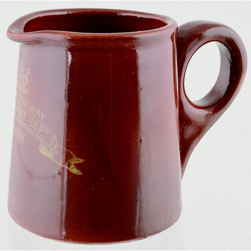 601 - DERBY RAILWAY CREAM JUG. 2ins tall. Brown body glaze, rear handle. Front transfer MIDLAND RAILWAY/ R... 