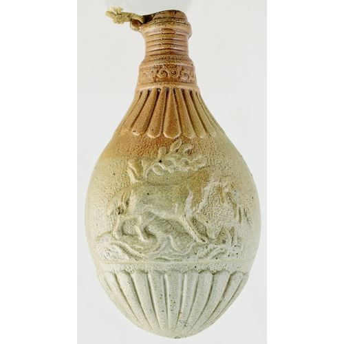 740 - POWDER FLASK. 8ins tall. Variating tan salt glaze, modelled as a gun powder-flask, decorated either ... 