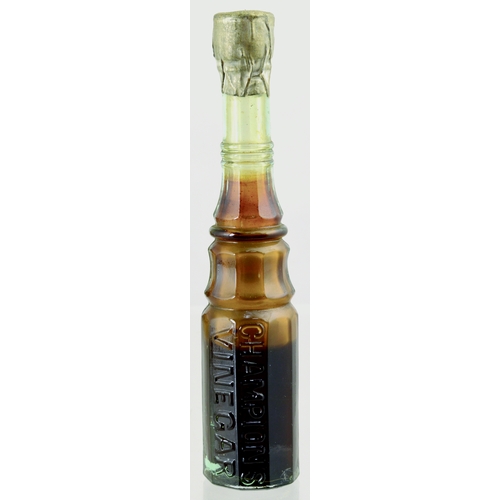 614 - VINEGAR SAMPLE BOTTLE. 5ins tall. Tall slender neck multi facetted bottle, vertically embossed CHAMP... 