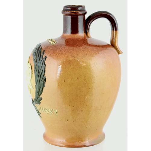 620 - J.R.D. SCOTCH WHISKY JUG. (WG p 157) 7ins tall. Variating tan salt glaze, rear handle, applied front... 