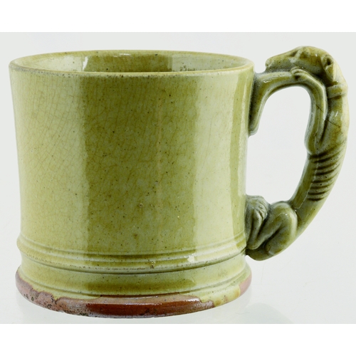 684 - GREYHOUND HANDLED MUG. 3.25ins tall. Grey/ green slip glaze mug, with greyhound handle. Light crazin... 