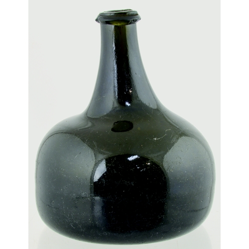 702 - TRANSITIONAL MALLET WINE BOTTLE. 6.5ins tall. Heavy, very dark green almost black glass, tapering ne... 