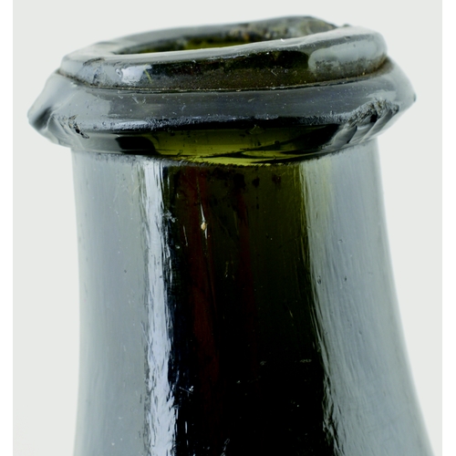 702 - TRANSITIONAL MALLET WINE BOTTLE. 6.5ins tall. Heavy, very dark green almost black glass, tapering ne... 