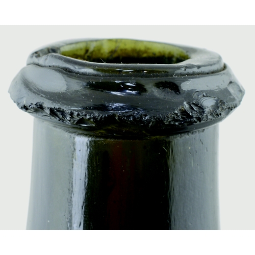 702 - TRANSITIONAL MALLET WINE BOTTLE. 6.5ins tall. Heavy, very dark green almost black glass, tapering ne... 