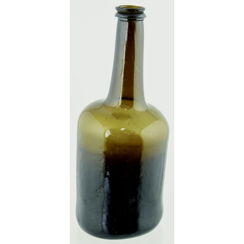 704 - FAT BODIED CYLINDER WINE BOTTLE. 9.75ins tall. Variating amber/ brown, slighlty dimpled glass, long ... 