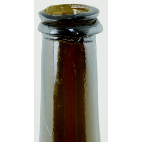 704 - FAT BODIED CYLINDER WINE BOTTLE. 9.75ins tall. Variating amber/ brown, slighlty dimpled glass, long ... 