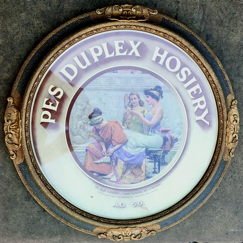 19 - PES DUPLEX HOSIERY FRAMED ADVERT. 18ins diam. Circular framed advert depicting lady being attended t... 