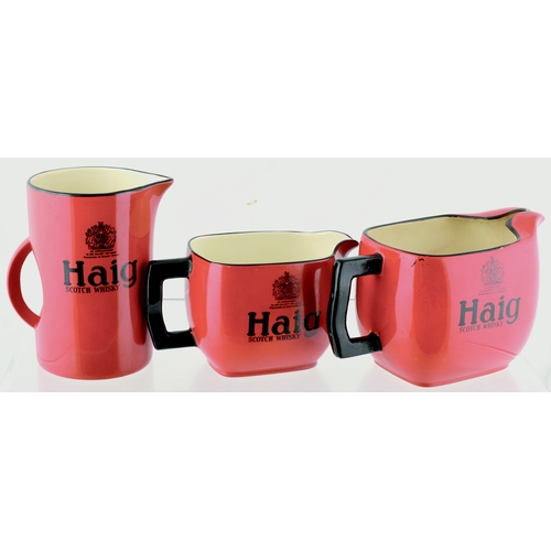 25 - HAIGS JUG TRIO. Tallest. 5.5ins. Three variations, red glaze with black detail HAIG/ SCOTCH WHISKY &... 